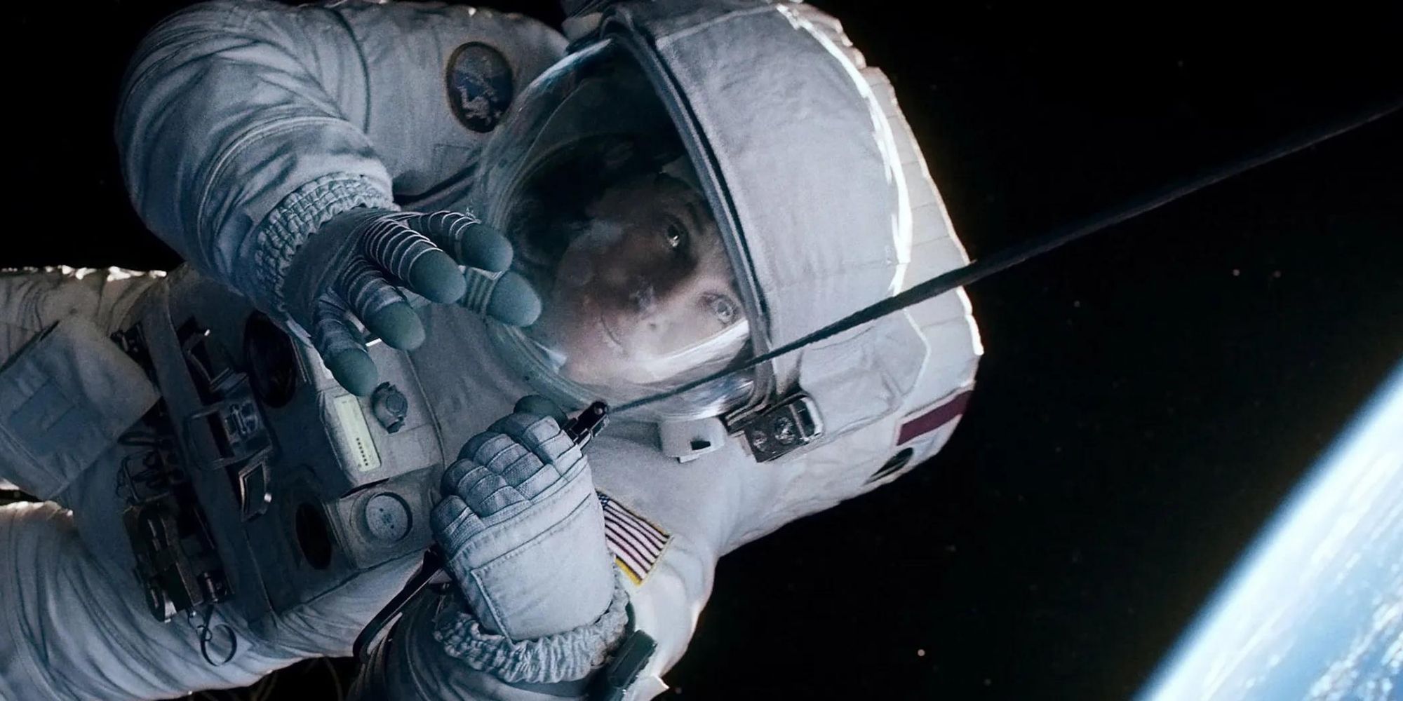 Sandra Bullock as Ryan Stone, holding onto a tether in space in 'Gravity'