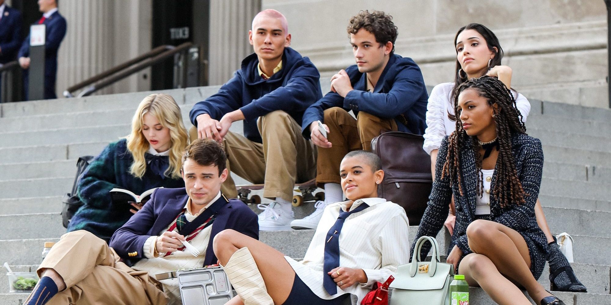 The cast of Gossip Girl (2021) sitting on the front steps of their high school.