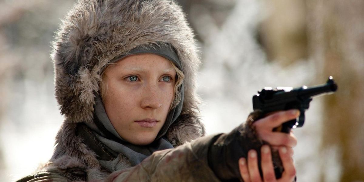 A young assassin aims her pistol on a cold winter's day.