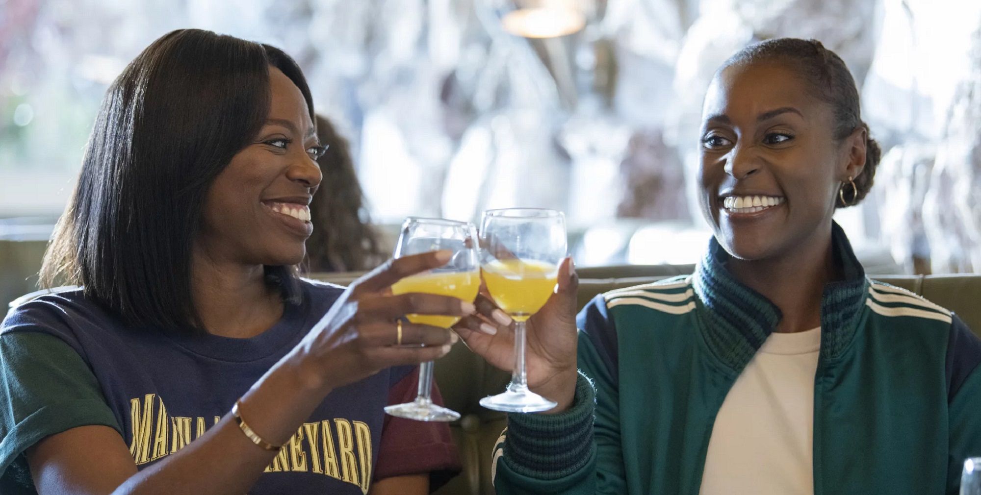 Two women smiling and toasting their drinks