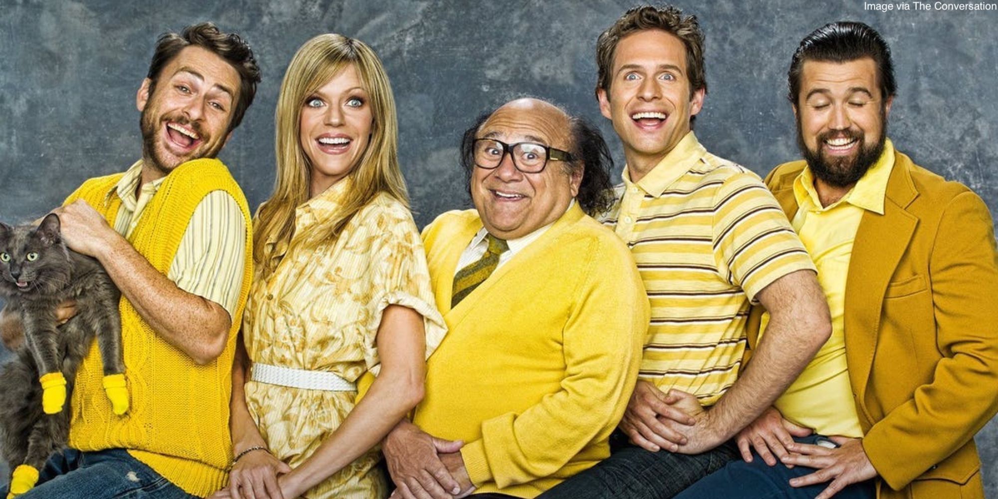 The gang from It's Always Sunny in Philadelphia smiling ridiculously for a photo whil dressed in yellow outfits.