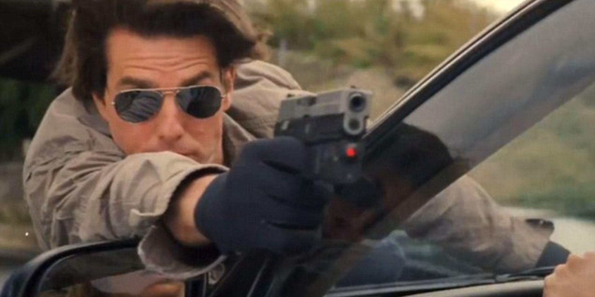 Tom Cruise hanging on the front of the car while aiming a gun in Knight and Day (2010)