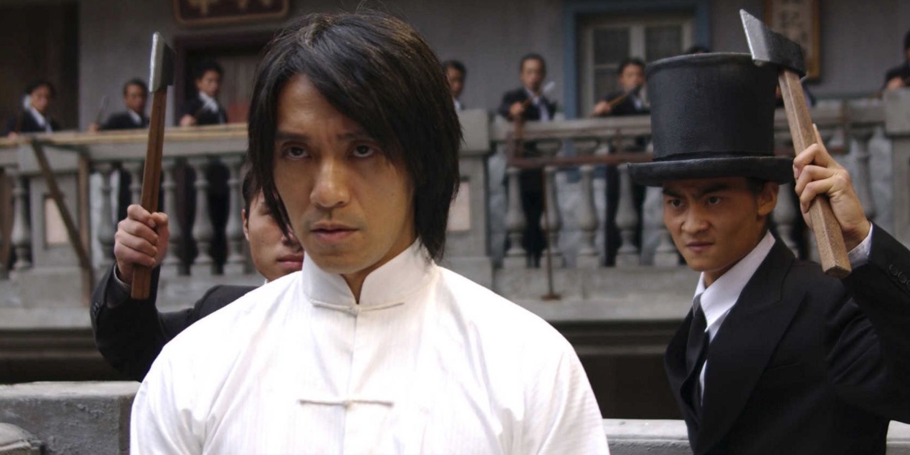 Stephen Chow and two other men standing behind him with axes in Kung Fu Hustle