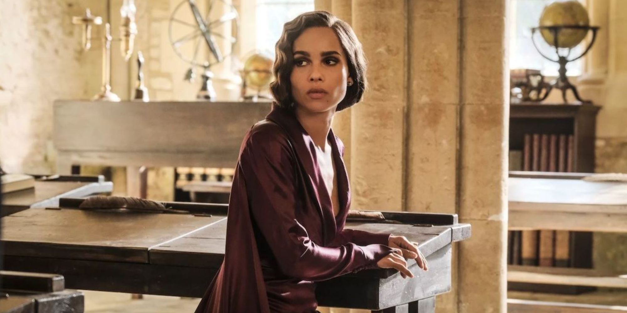 Leta Lestrange looks backwards in her chair at a desk in a marble room