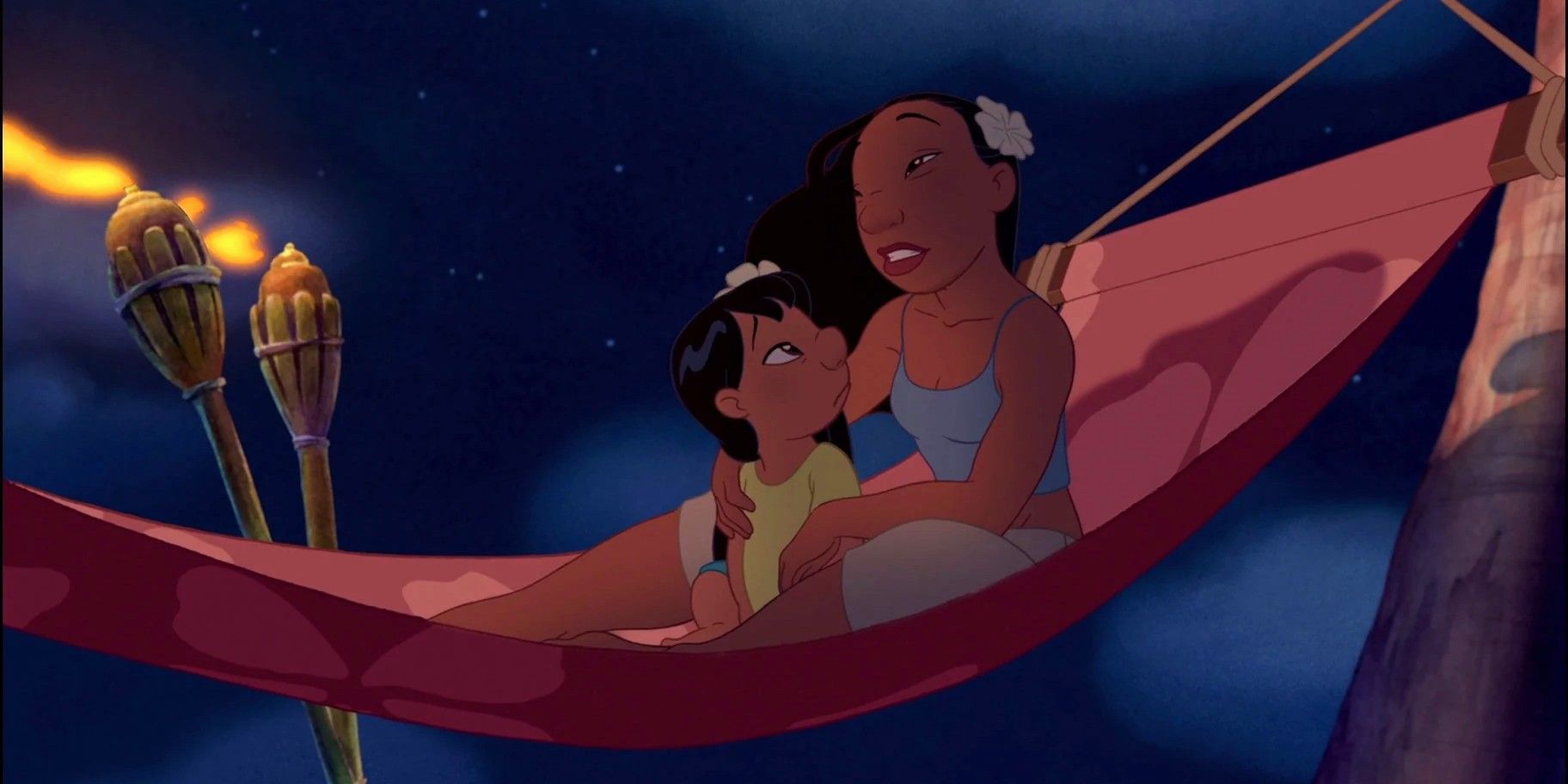 Nani cradles Lilo in a hammock lit by torches against the night sky.