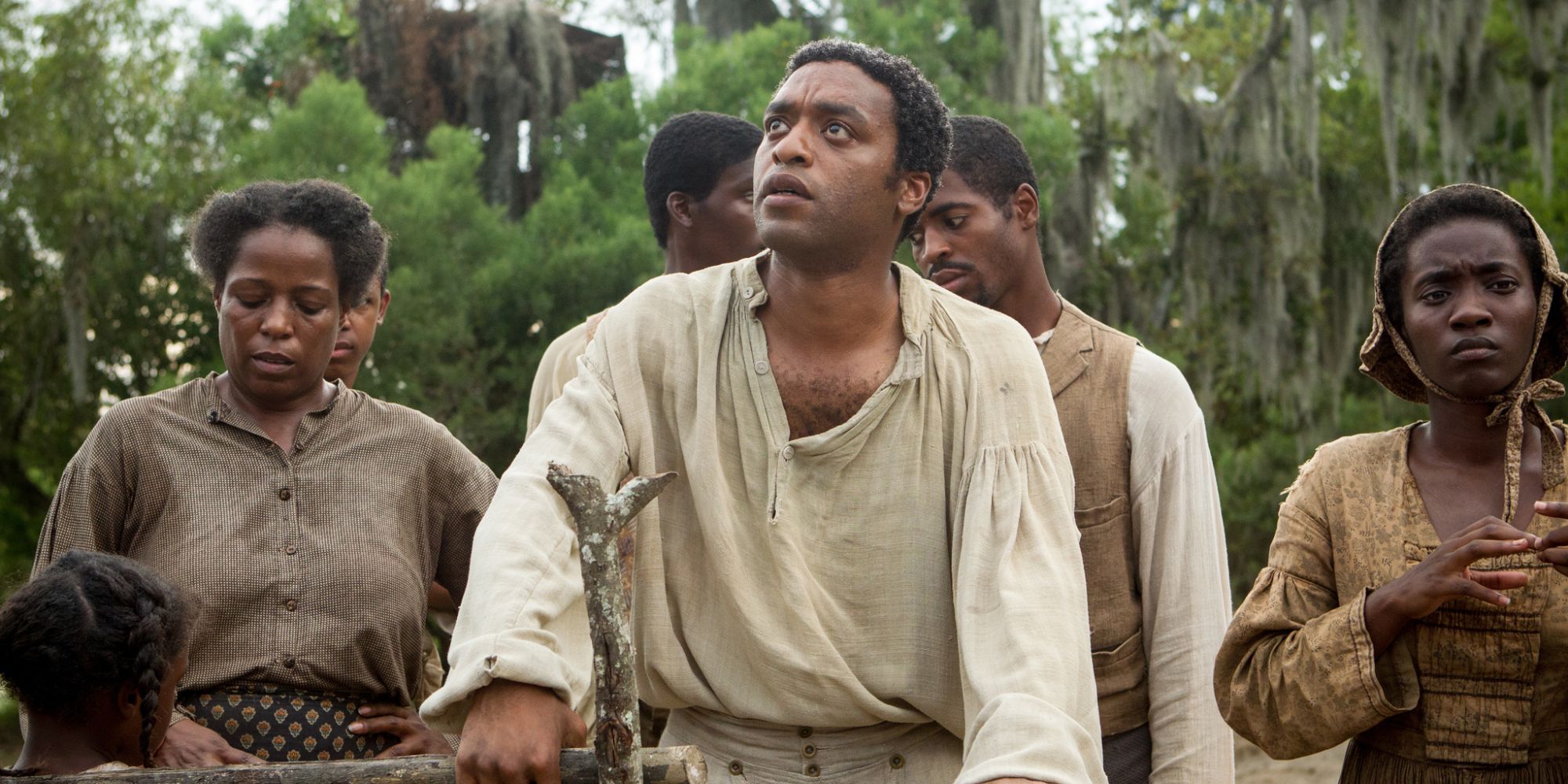 Chiwtele Ejiofor as Solomon Northup alongside a group of slaves in a plantation in 12 Years a Slave.