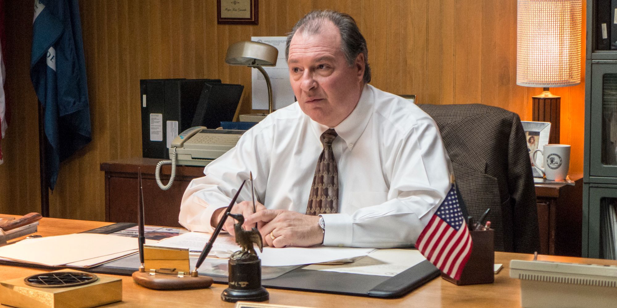 A man is sitting at his desk annoyed