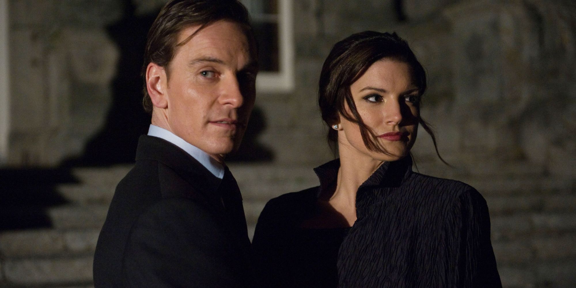 Michael Fassbender and Gina Carnao as Kane and Mallory standing at night on a street looking in different directions in the film Haywire