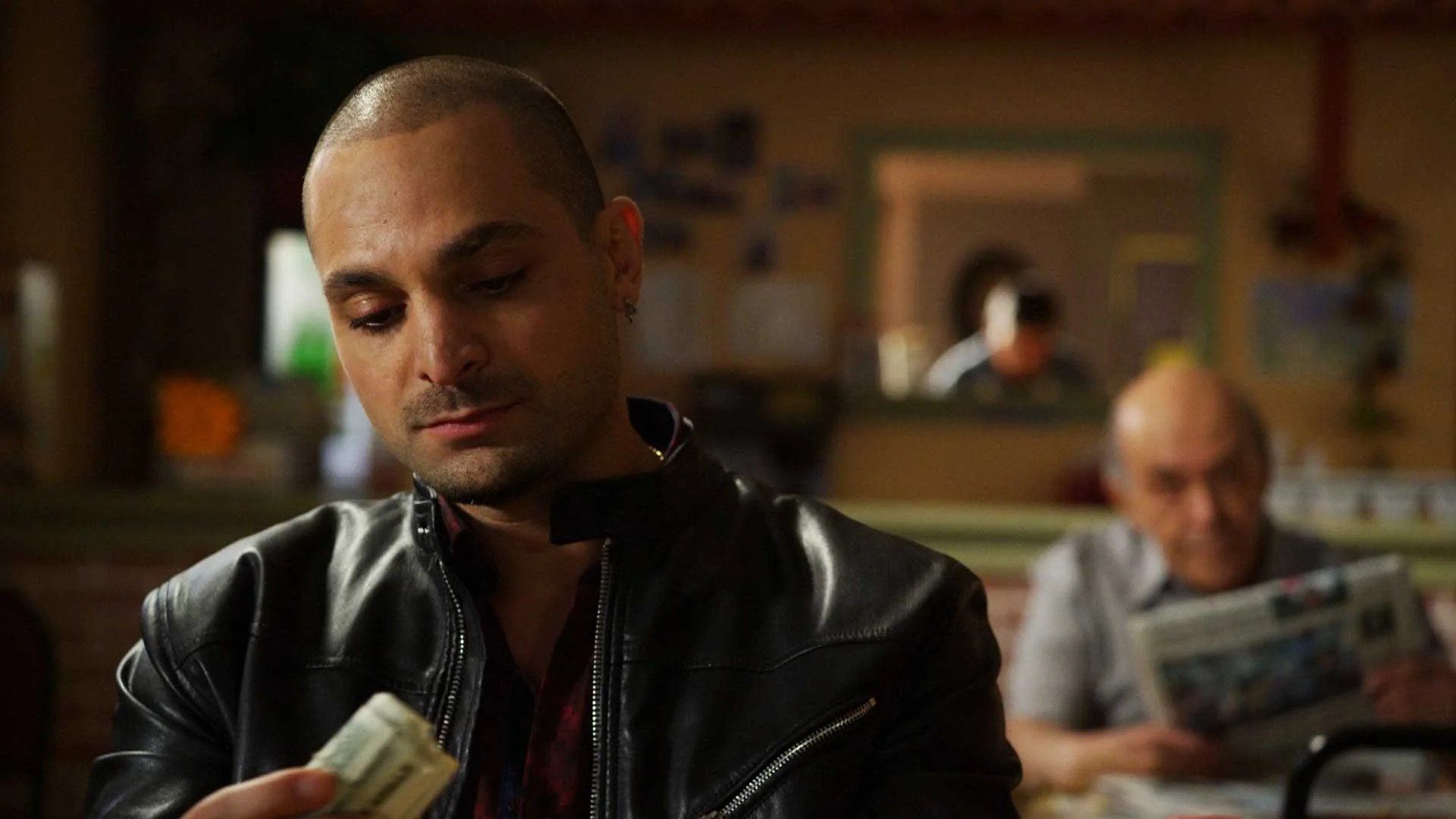 Nacho from "Better Call Saul" with some money, Hector looking at him from behind