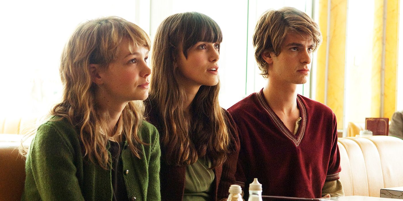 Kathy, Ruth, and Tommy sitting side by side looking ahead in Never Let Me Go