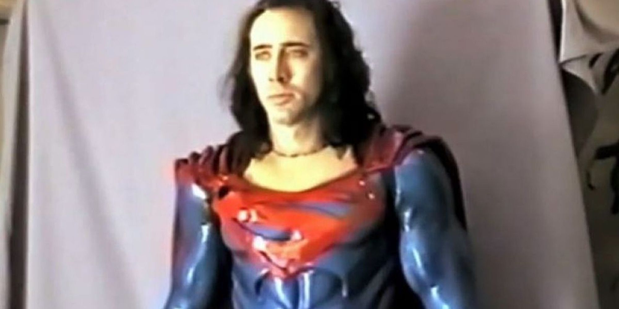 Nicolas Cage in a photoshoot in costume as Superman, looking at the camera