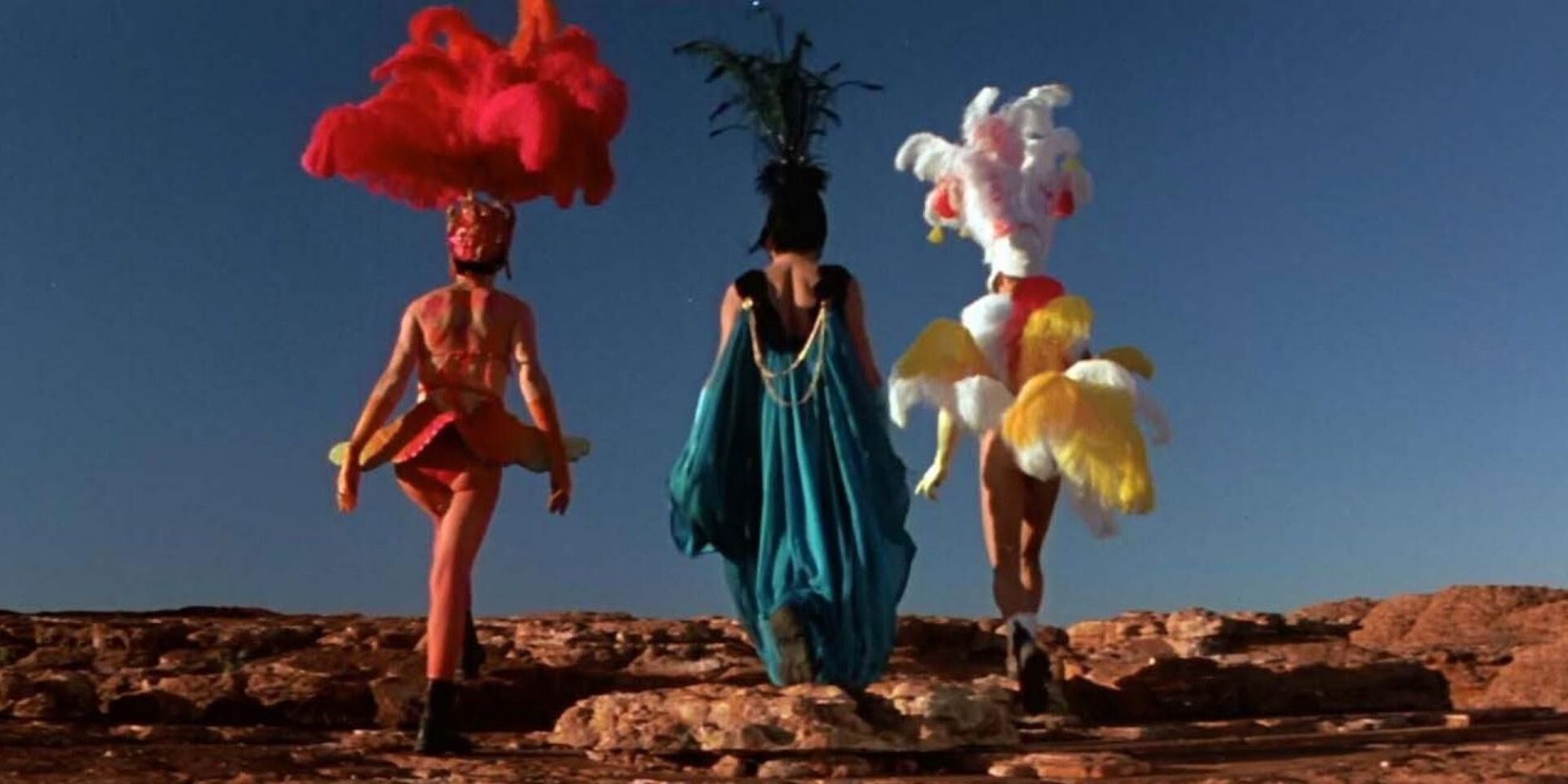 Two drag queens and a transgender woman walking in the desert in costume