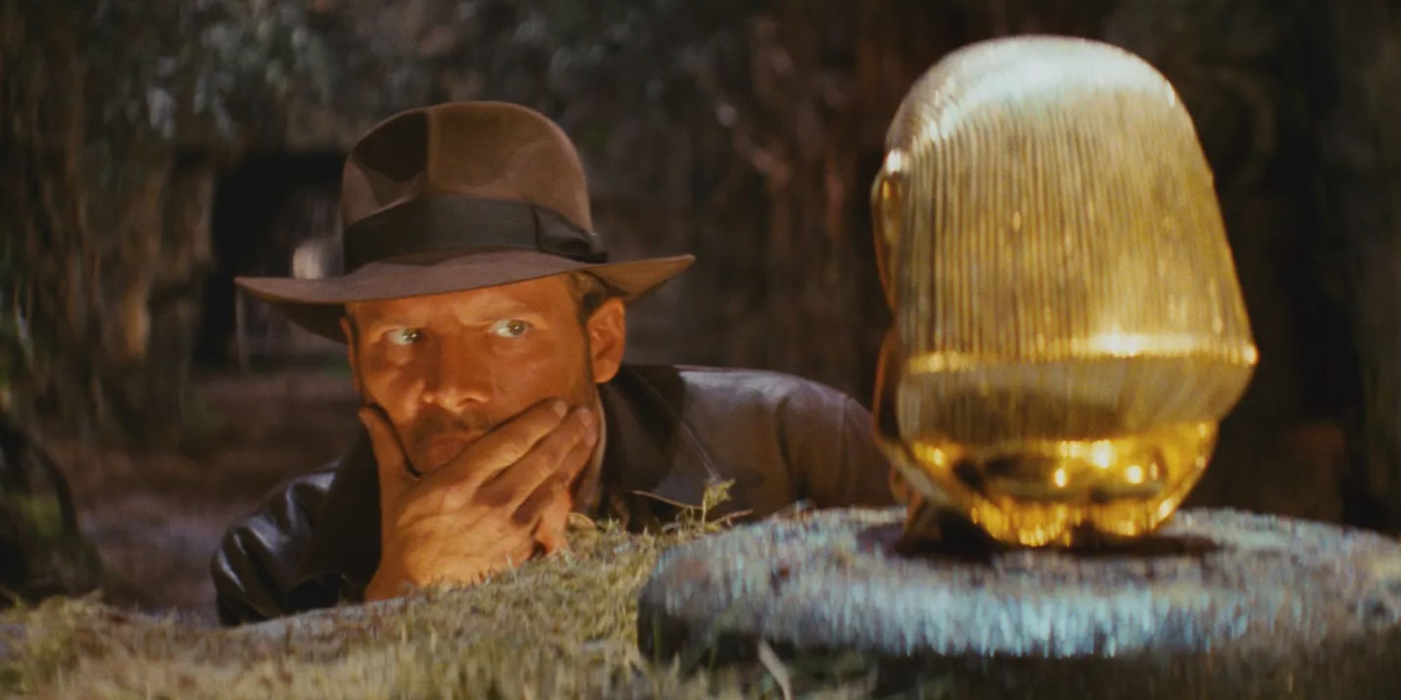 Harrison Ford as Indiana Jones, looking at the artifact 