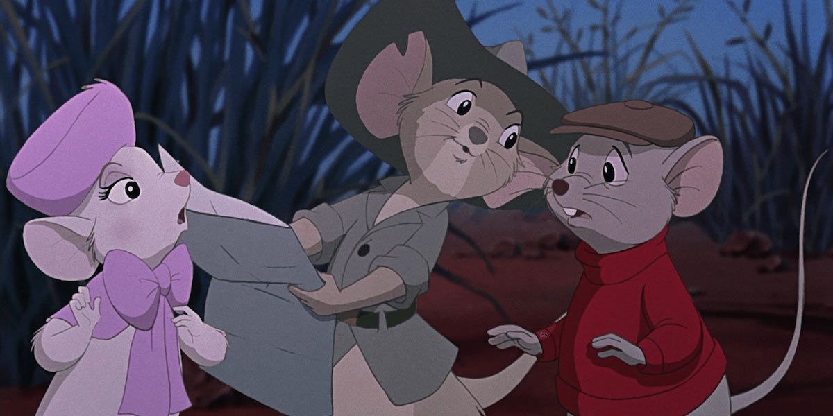 Trois souris étudient une carte dans l'herbe.