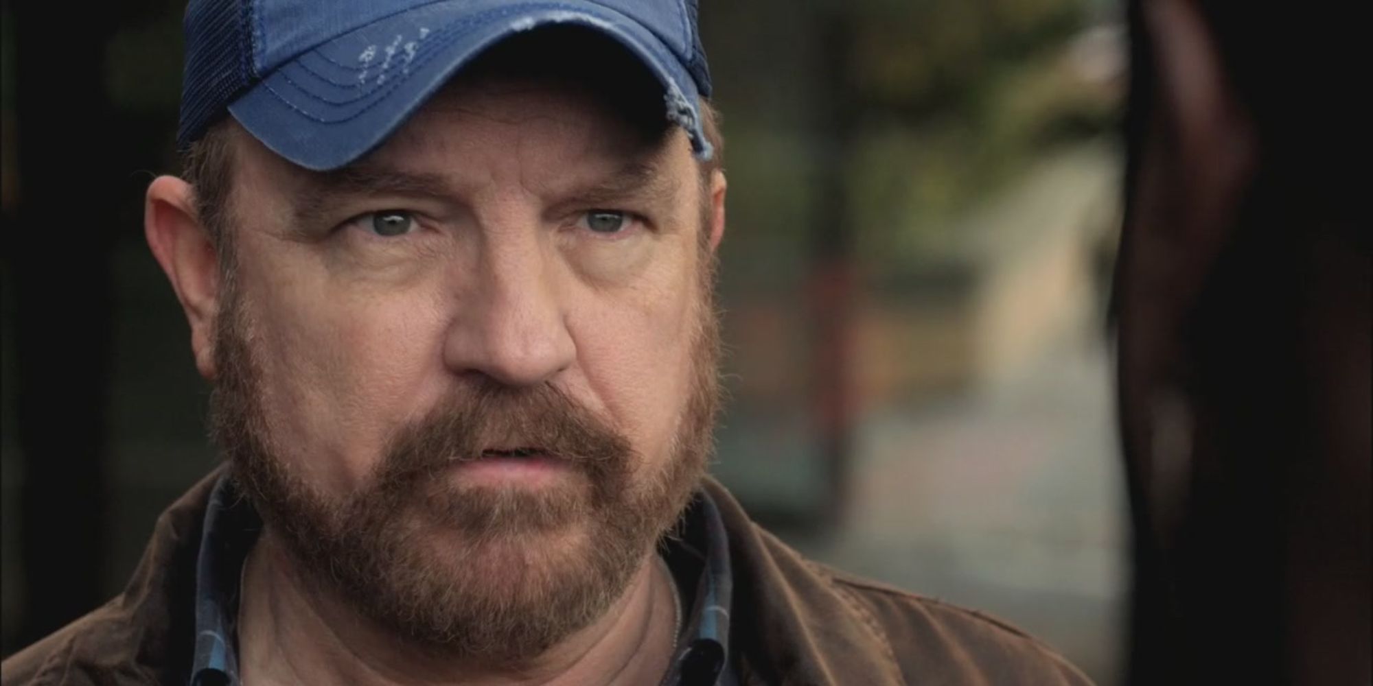 Bobby Singer wearing a ball cap.