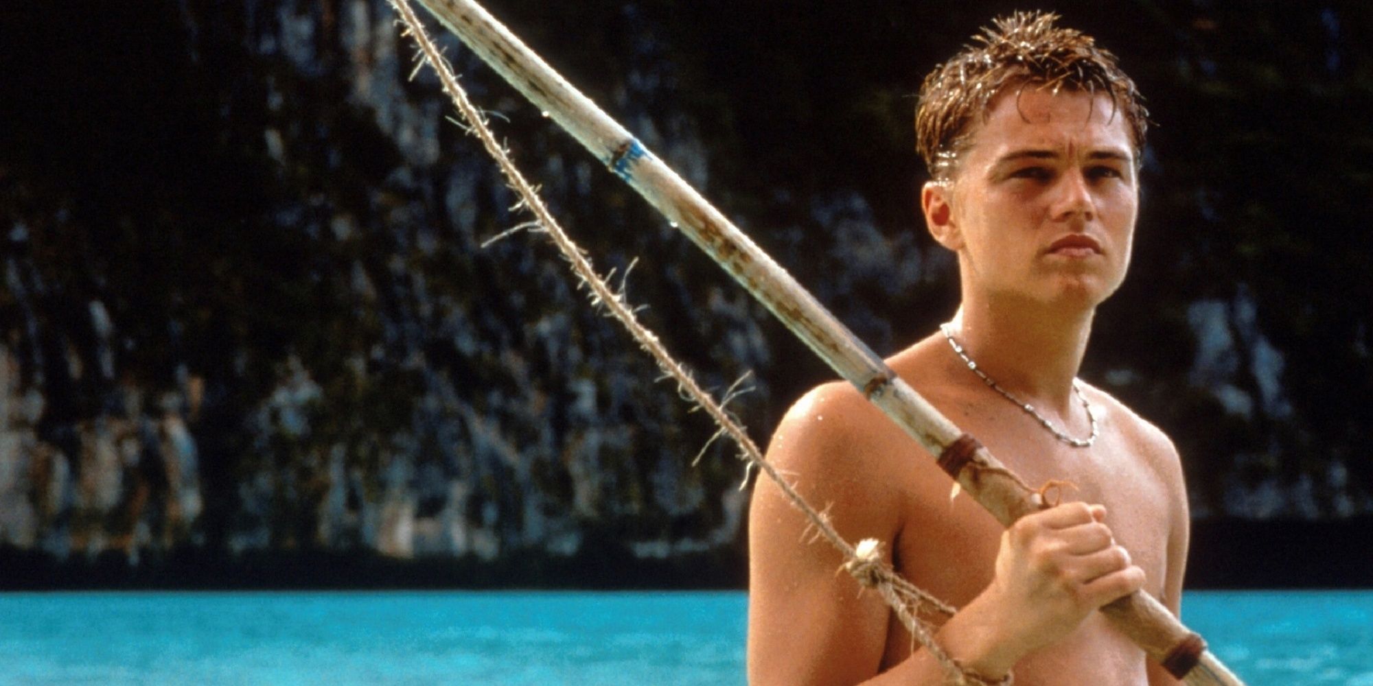 Leonardo DiCaprio with a fishing spear on the beach in The Beach.