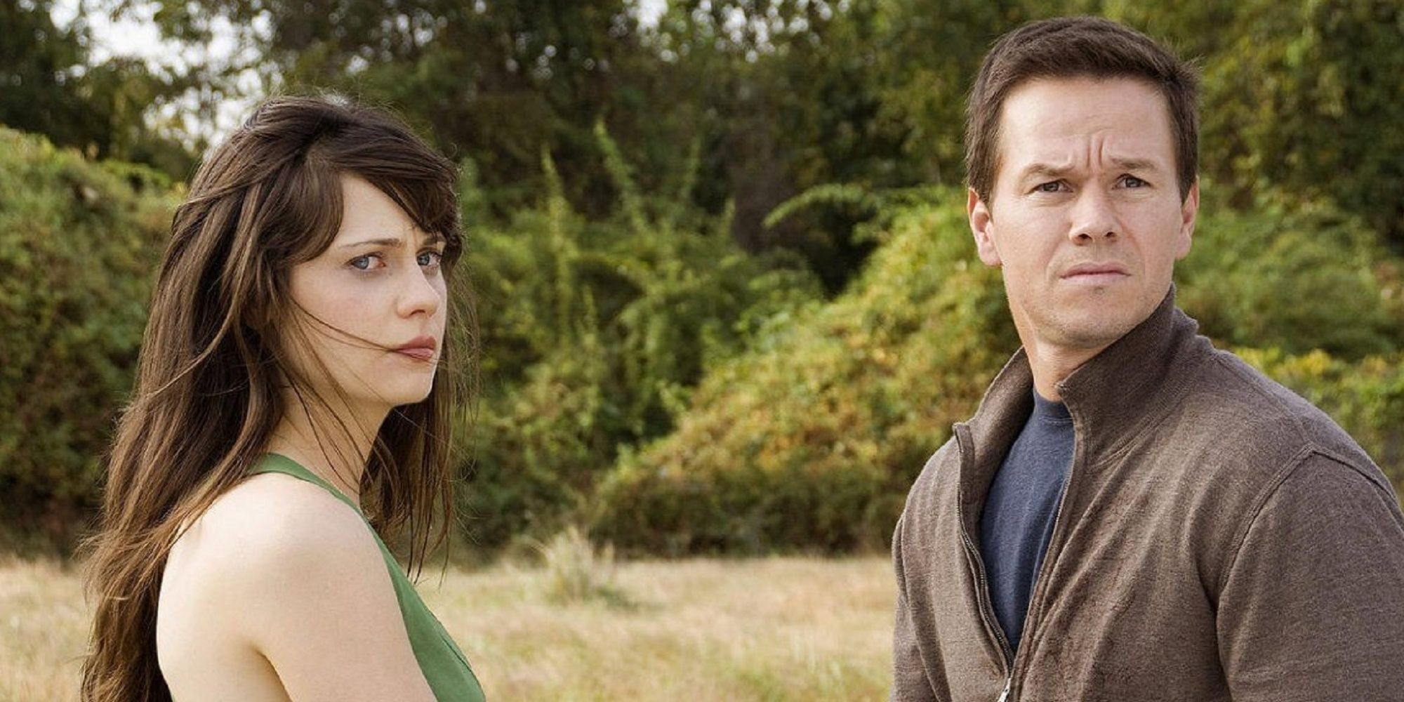 A woman and a man stands next to each other in a field