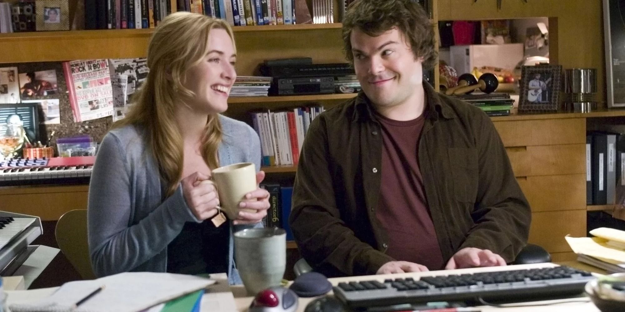 Kate Winslet boit un café et est assise à côté de Jack Black qui joue du piano.