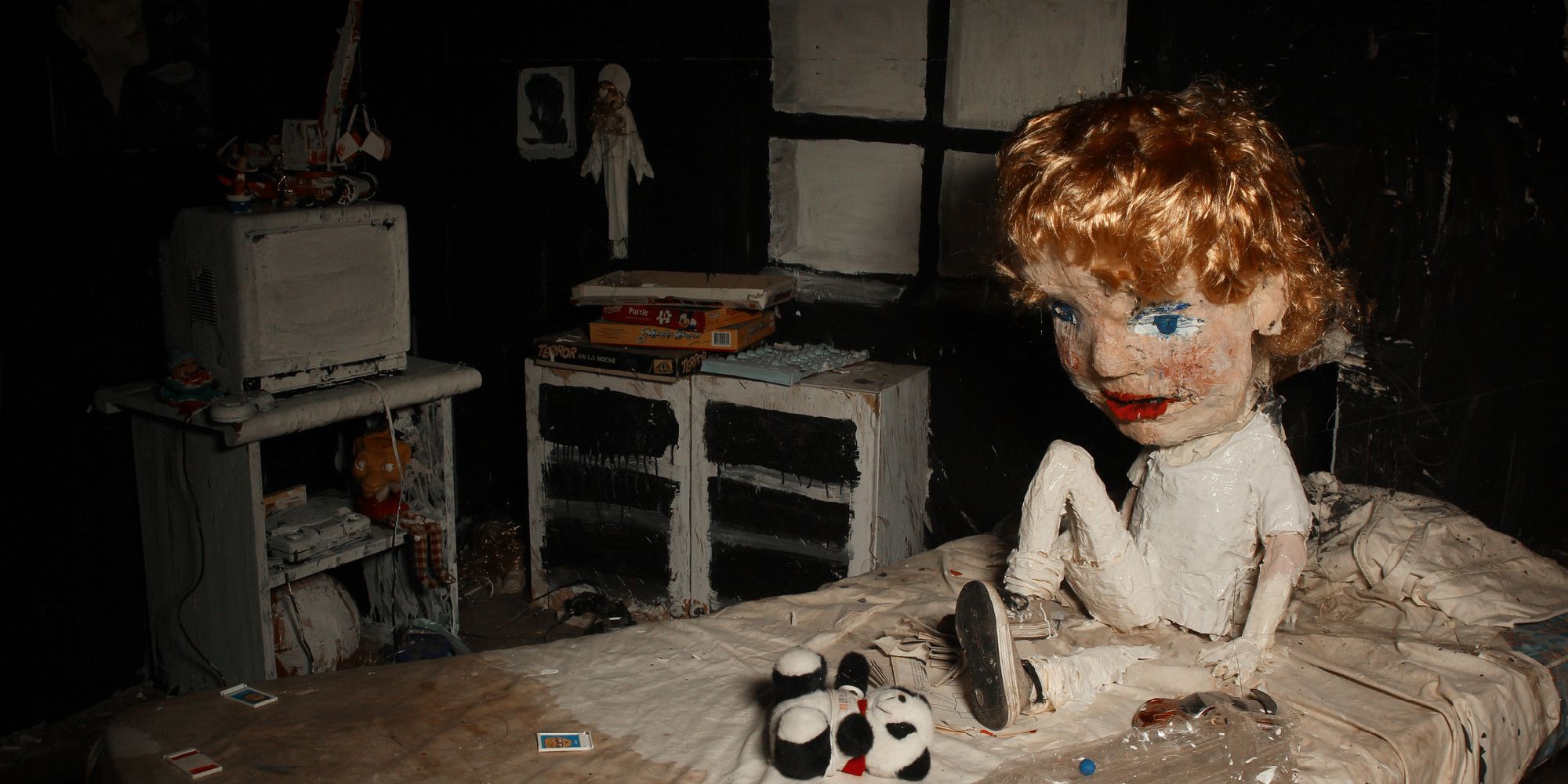 Une poupée est assise sur un lit dans The Wolf House
