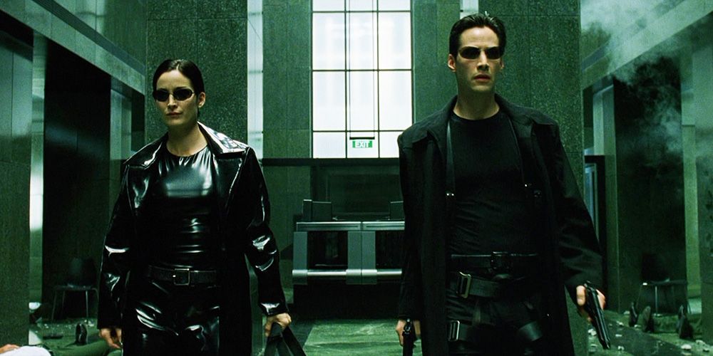 Trinity et Neo marchant dans une pièce vide de Matrix.