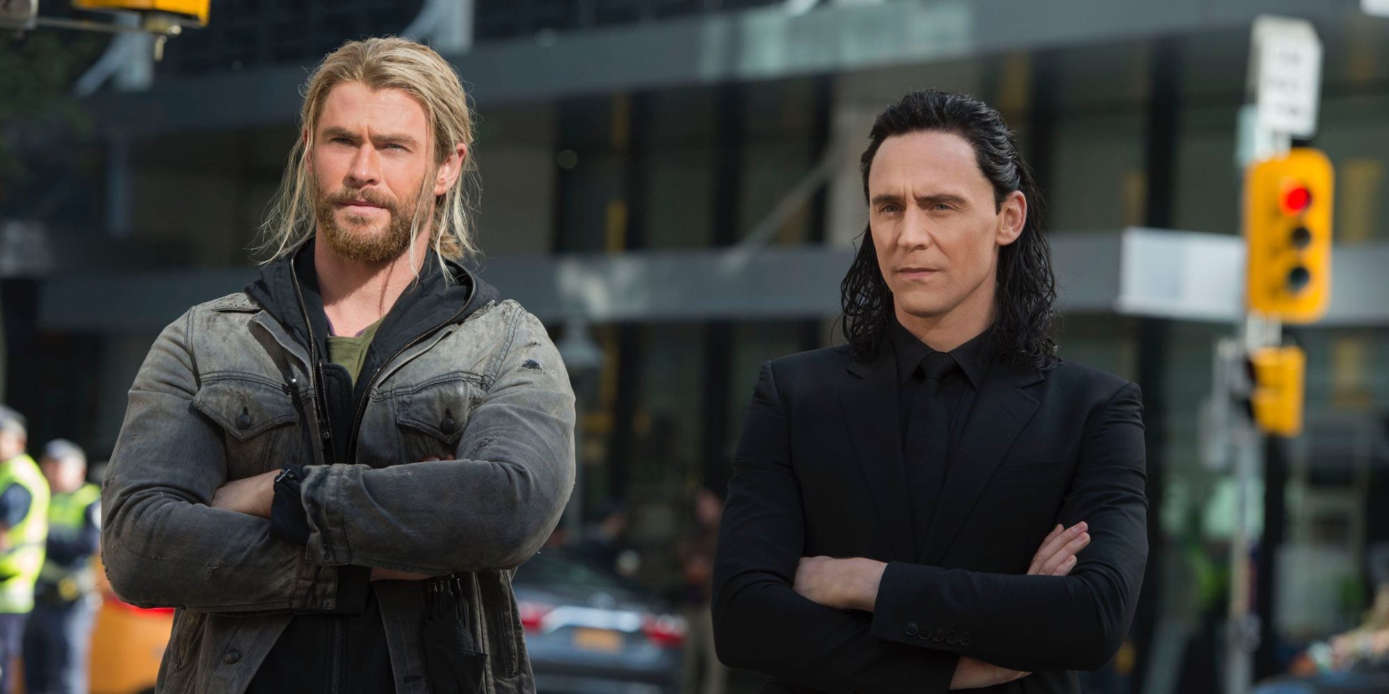 Chris Hemsworth and Tom Hiddleston as Thor and Loki looking ahead with their arms crossed in Thor: Ragnarok