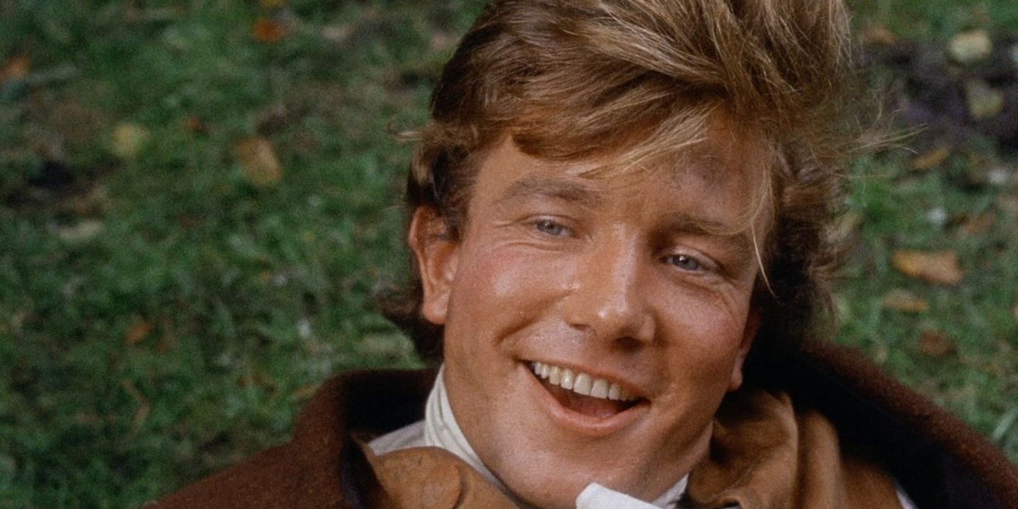 character Tom Jones in the movie of the same name, laughing while lying on the grass
