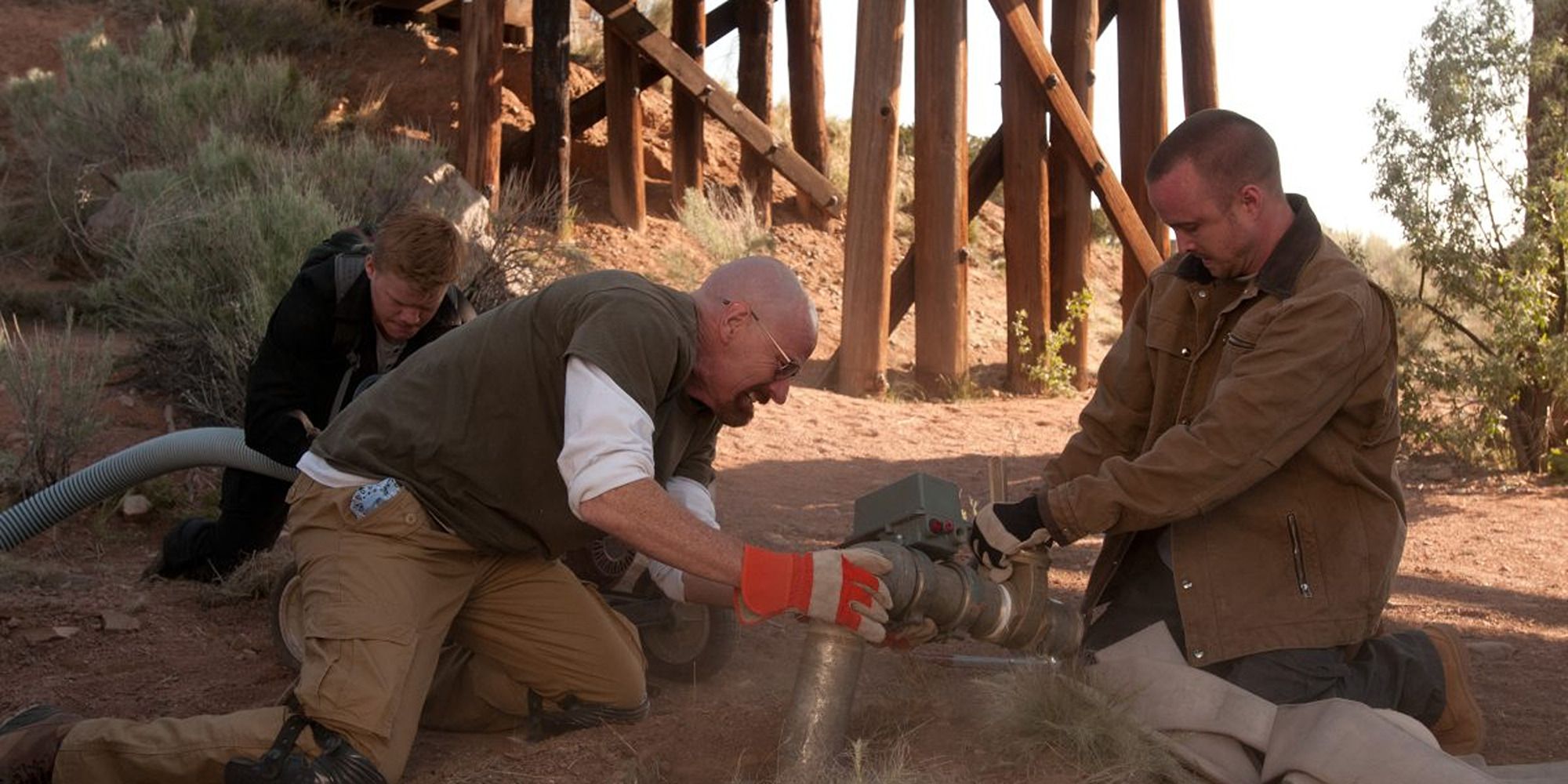 Walt, Jesse, and Todd from "Breaking Bad" preparing a hose to rob methylamine from a train