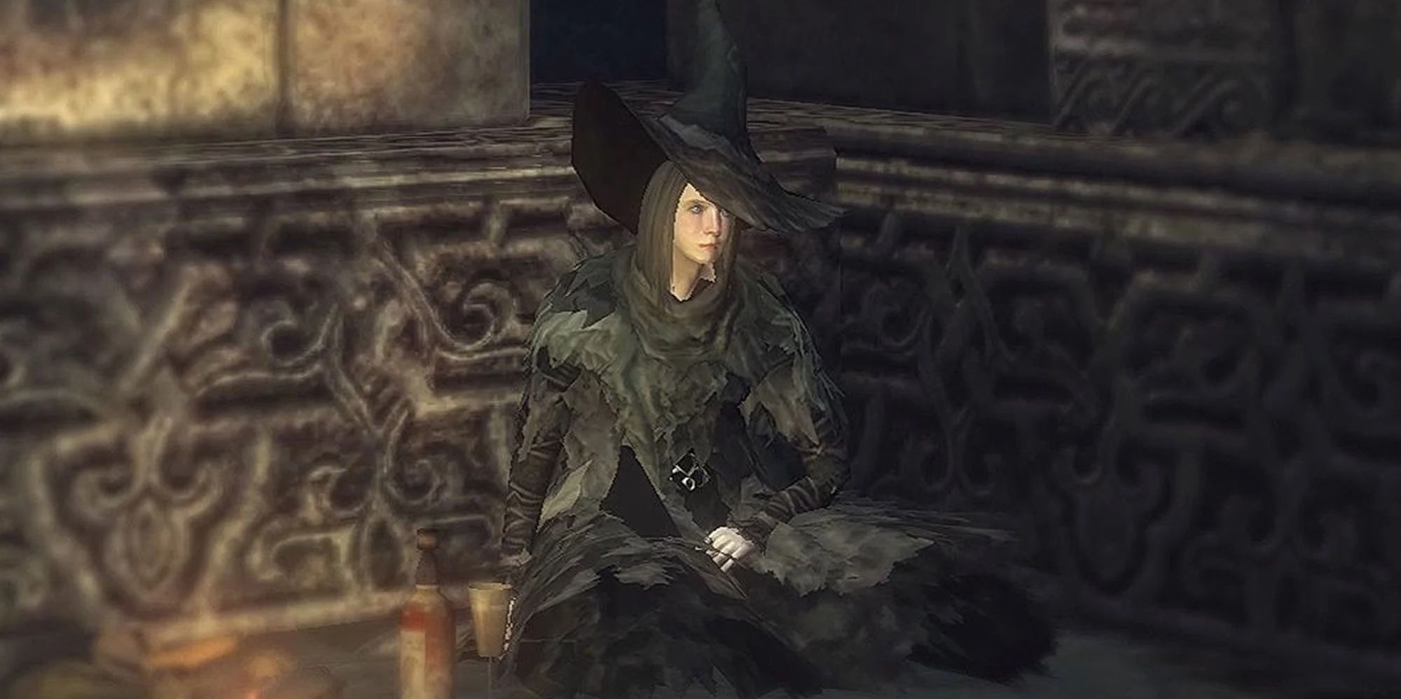 Yuria, the Witch sitting on the floor in her witchs hat in Demons Souls.