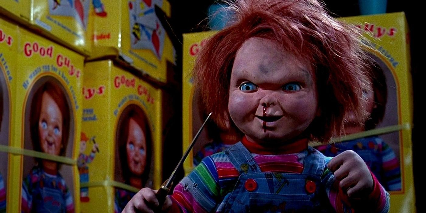 Chucky holding up a knife and smiling in Child's Play 2