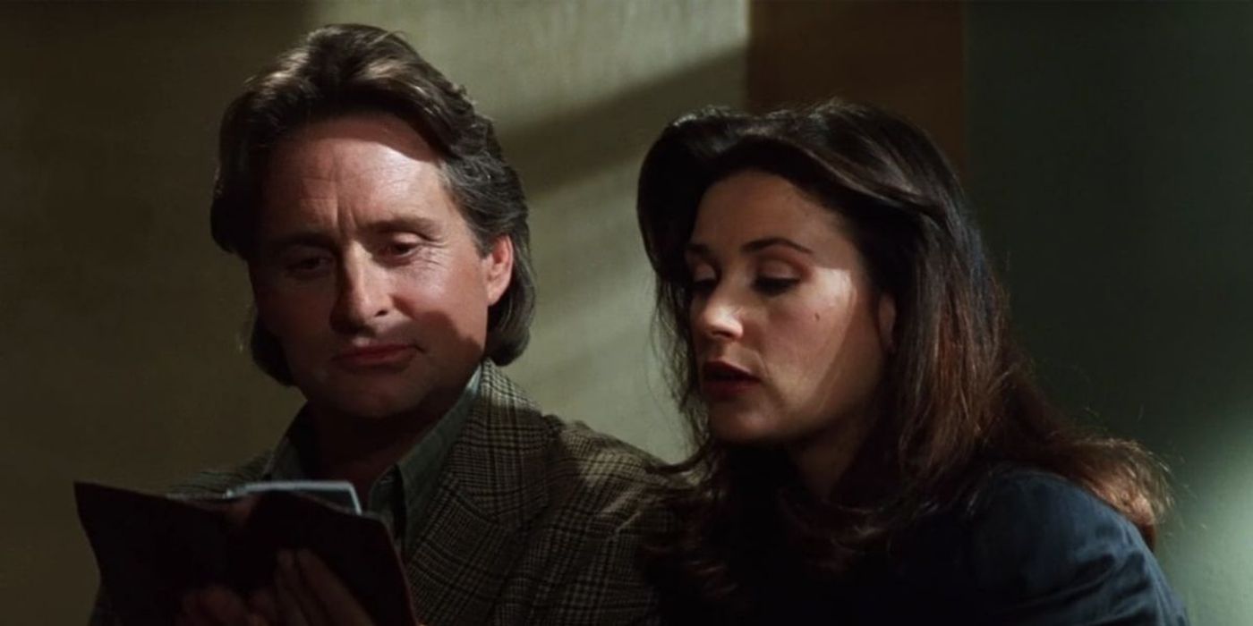 Michael Douglas and Demi Moore looking at a book in 'Disclosure' (1994).