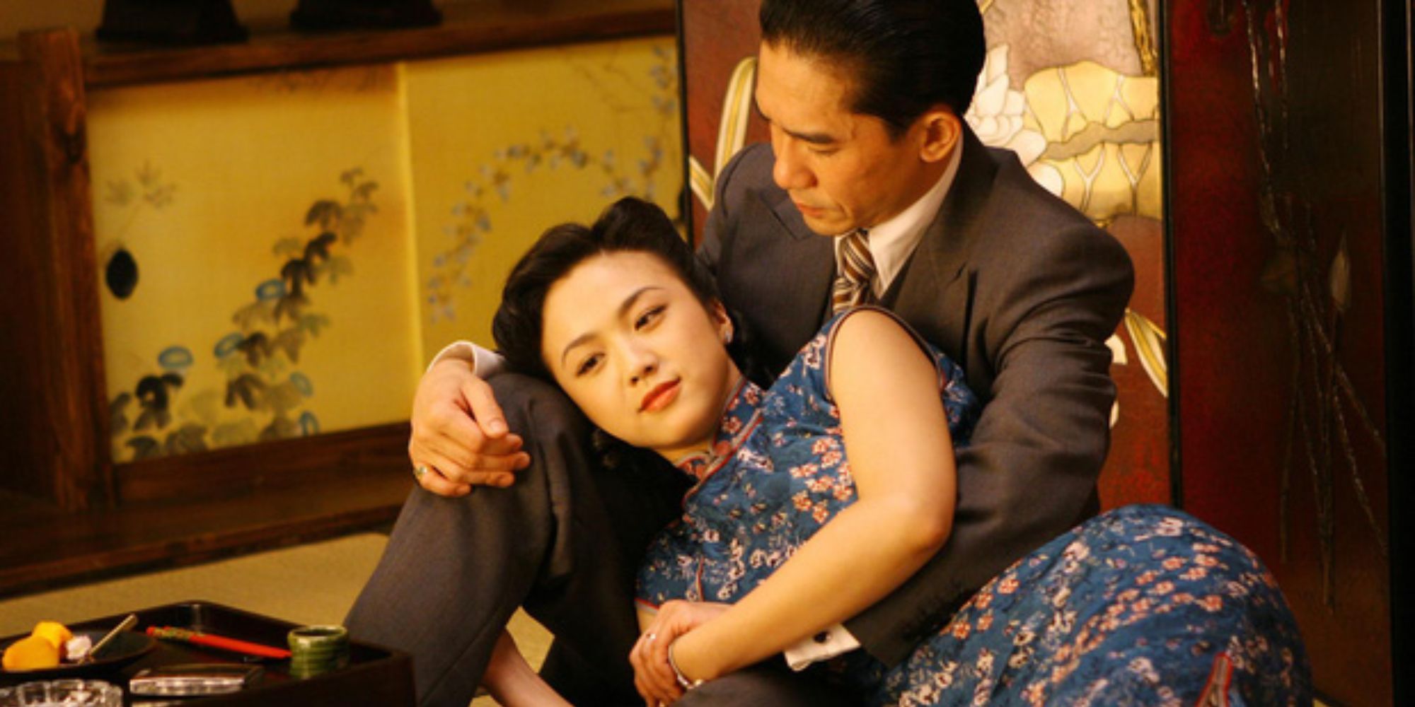 A Chinese woman in blue Chinese cheongsam lying on a man&rsquo;s lap