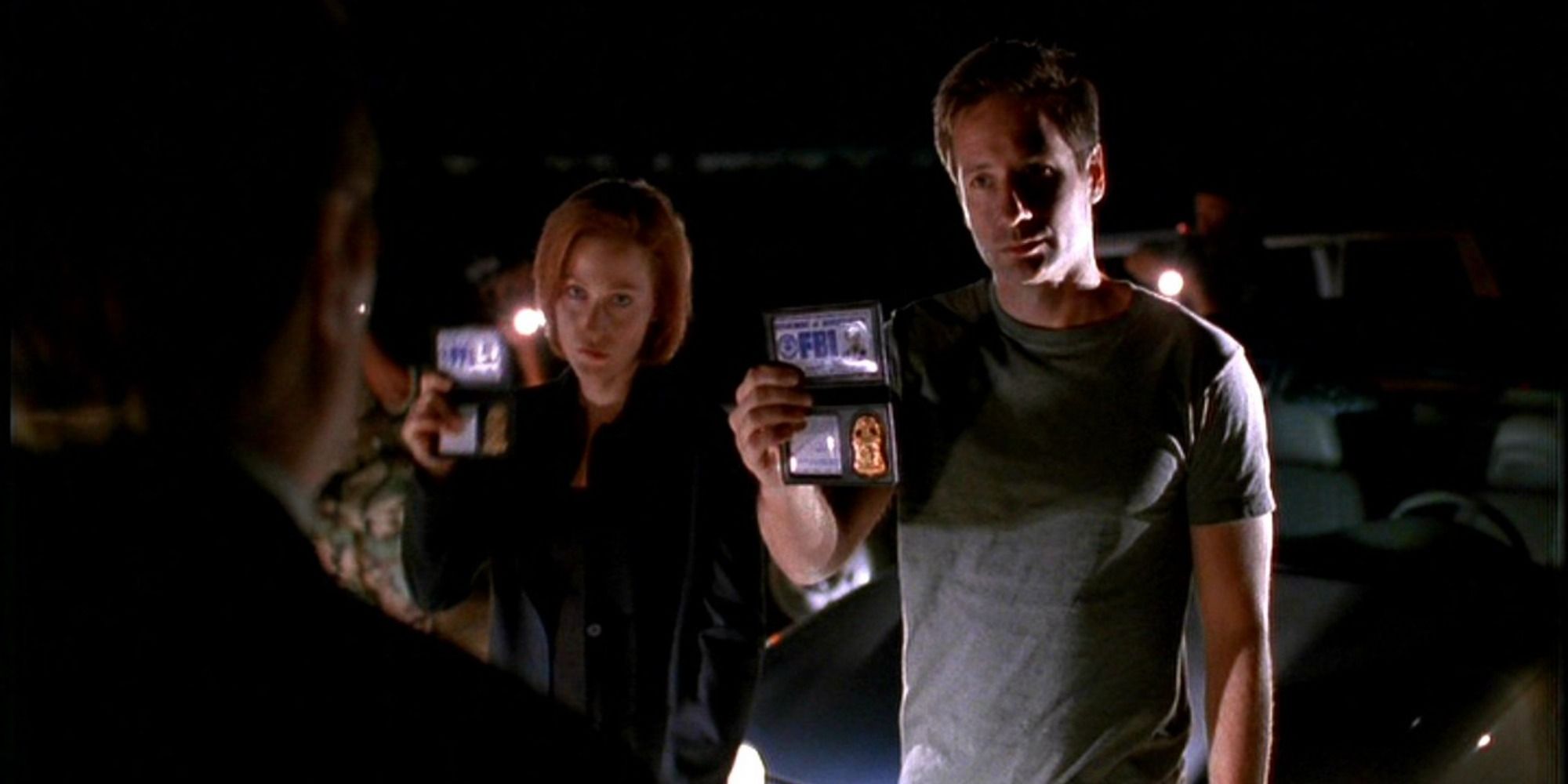 Gillian Anderson and David Duchovny show their badges in The X-Files