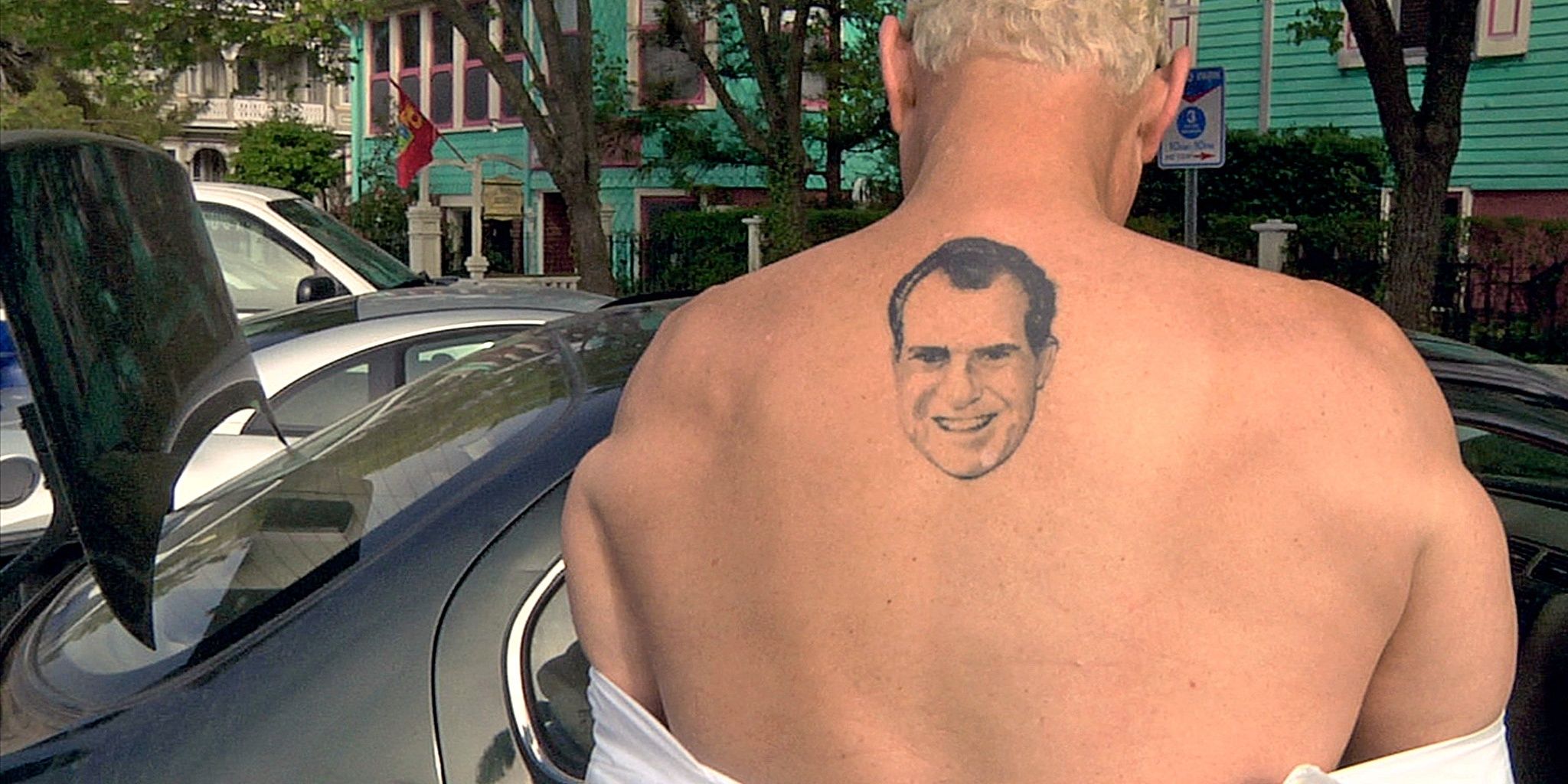 Roger Stone Nixon back tattoo, white hair next to car