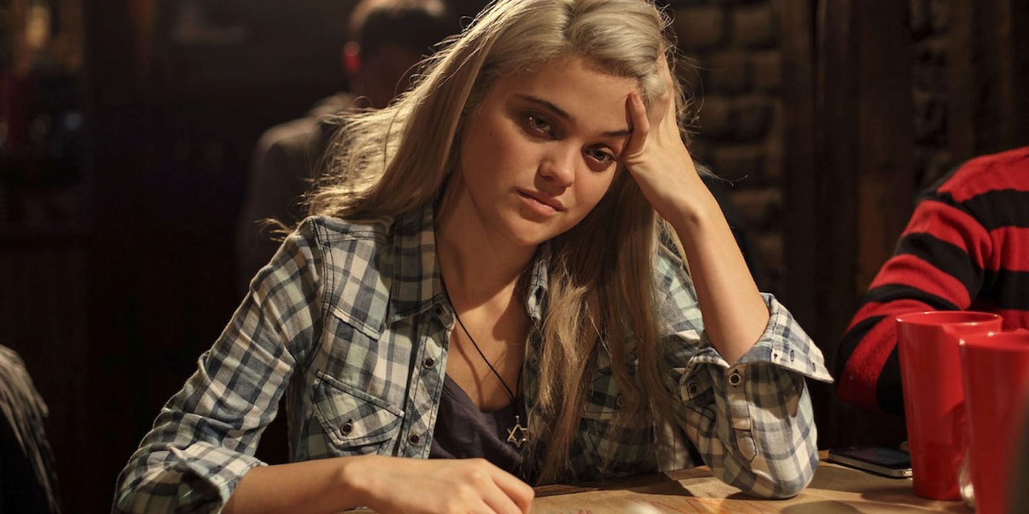 sky ferreira in the green inferno at a bar hand on forehead