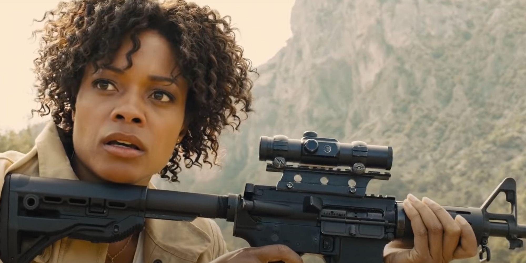Naomie Harris Moneypenny with a rifle, shocked that she has accidentally shot Bond.