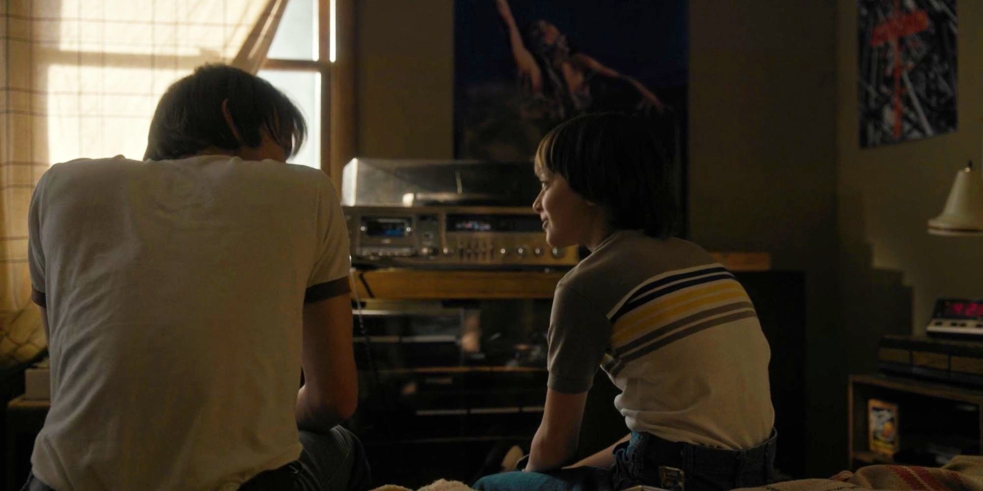 Will and Jonathan Byers talking while sitting on a bed in Stranger Things