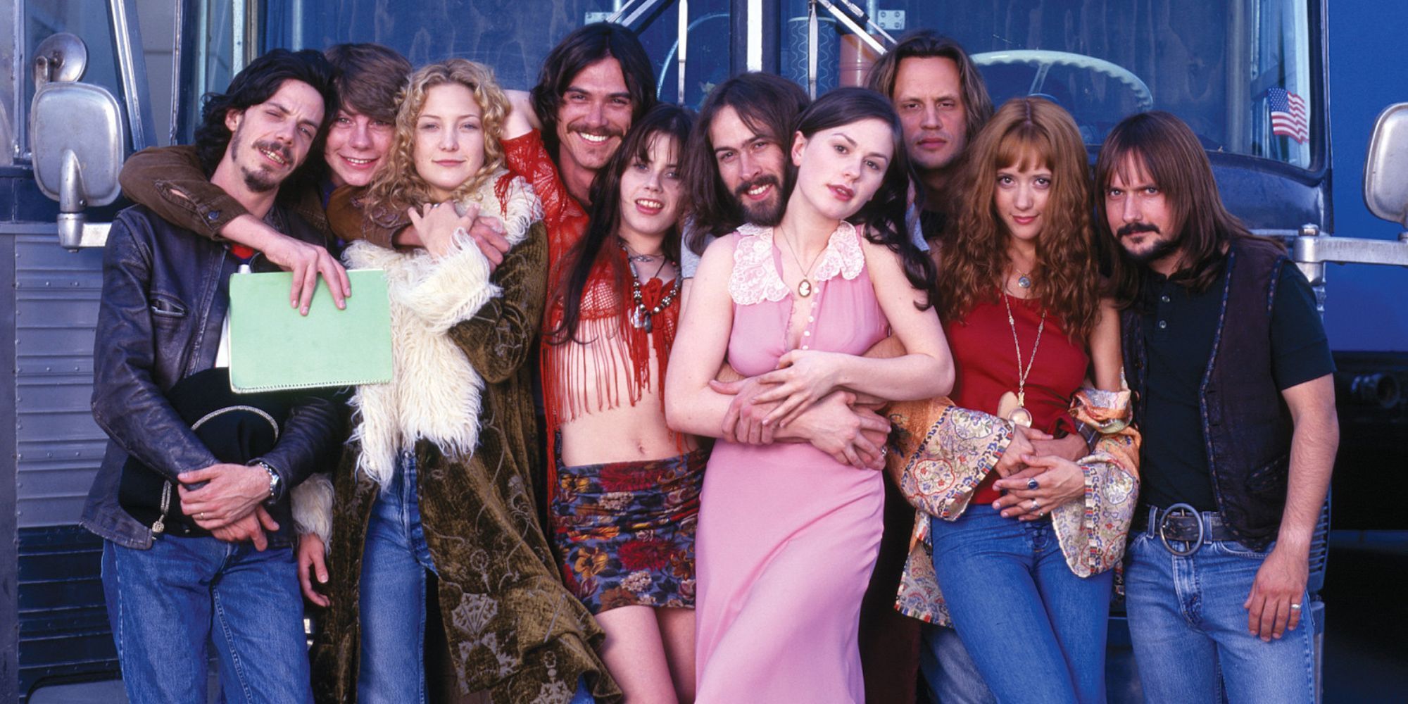 The cast of Almost Famous posing in front of a bus.