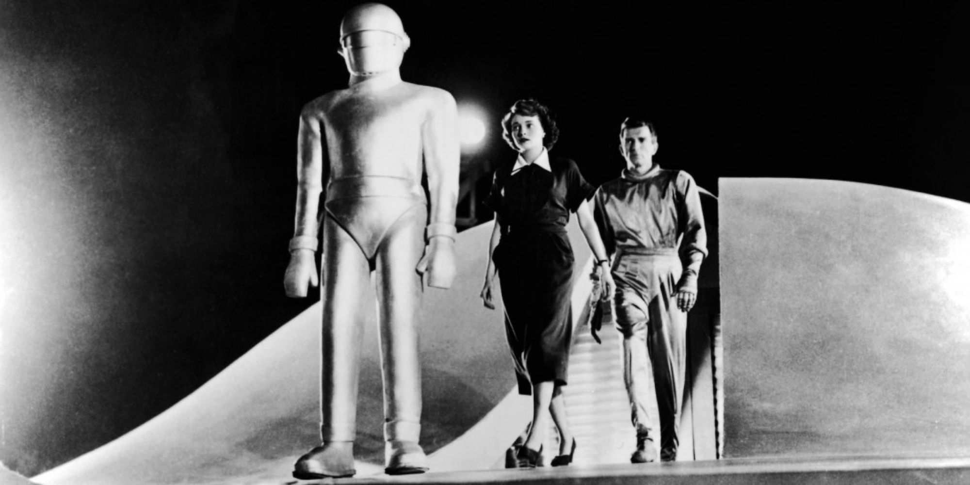 A robot and two people emerging from a spaceship