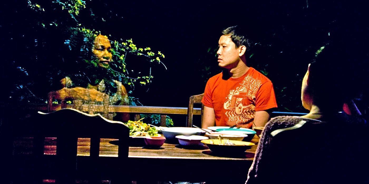 A man sitting at the dinner table looking at a transparent apparition sitting next to him in &lsquo;Uncle Boonmee Who Can Recall His Past Lives&rsquo;