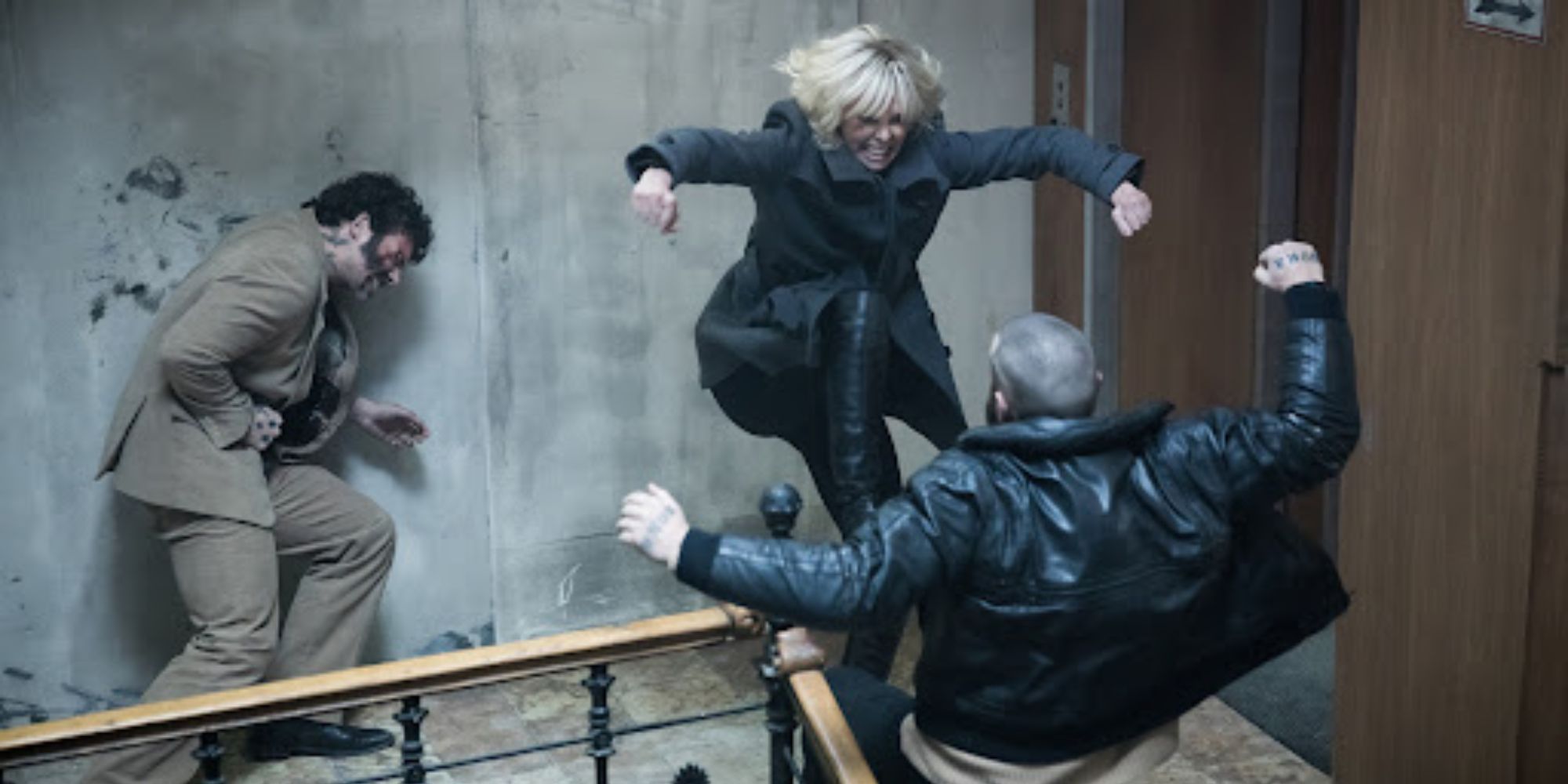 Charlize Theron fighting two men on a staircase in Atomic Blonde