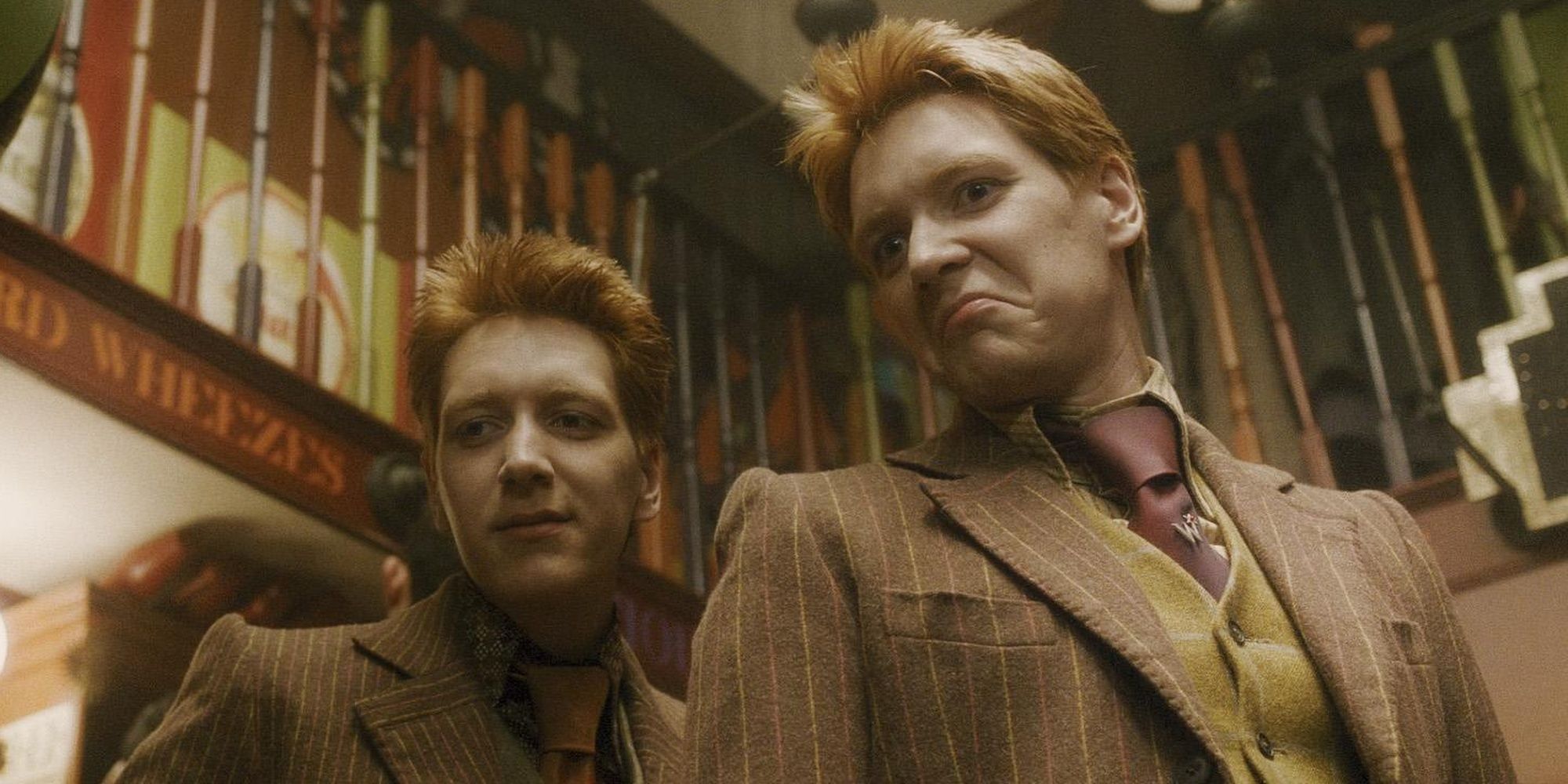 Fred and George Weasley stand on the steps in their joke shop