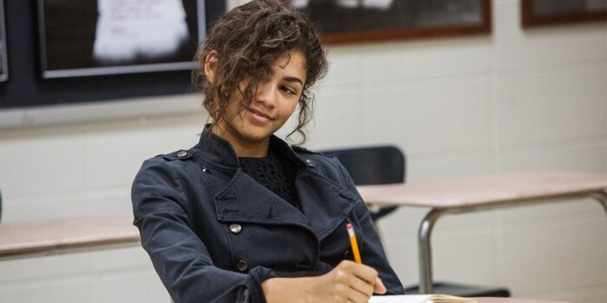 MJ sitting at a desk, drawing and side-eyeing someone in Spider-Man: Homecoming.