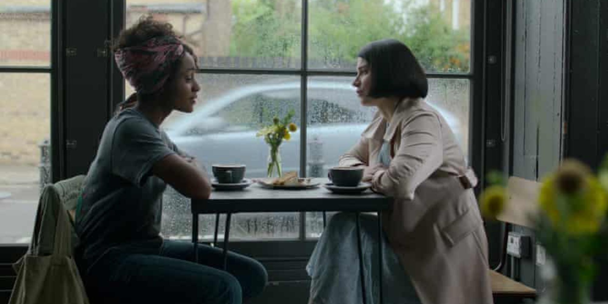 two women sitting at a cafe on a rainy day