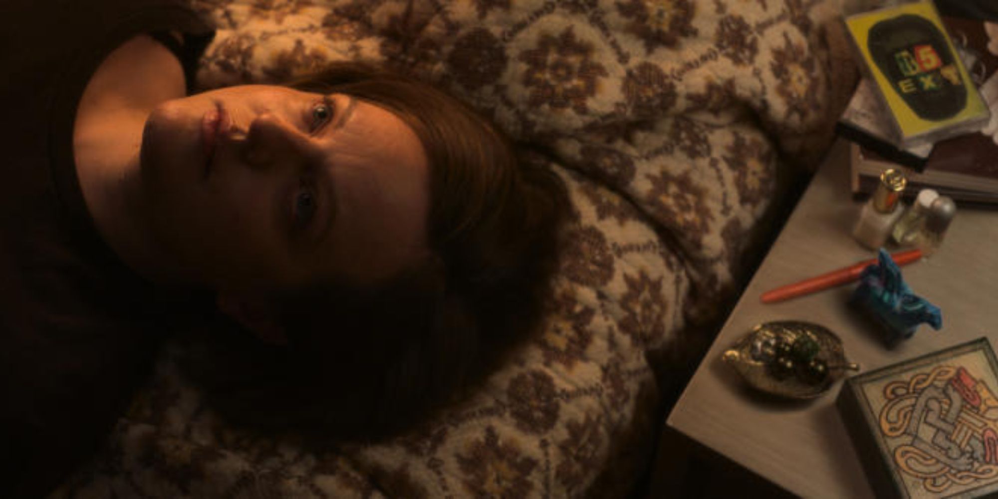 Elizabeth Moss in Shining Girls laying face-up on a bed