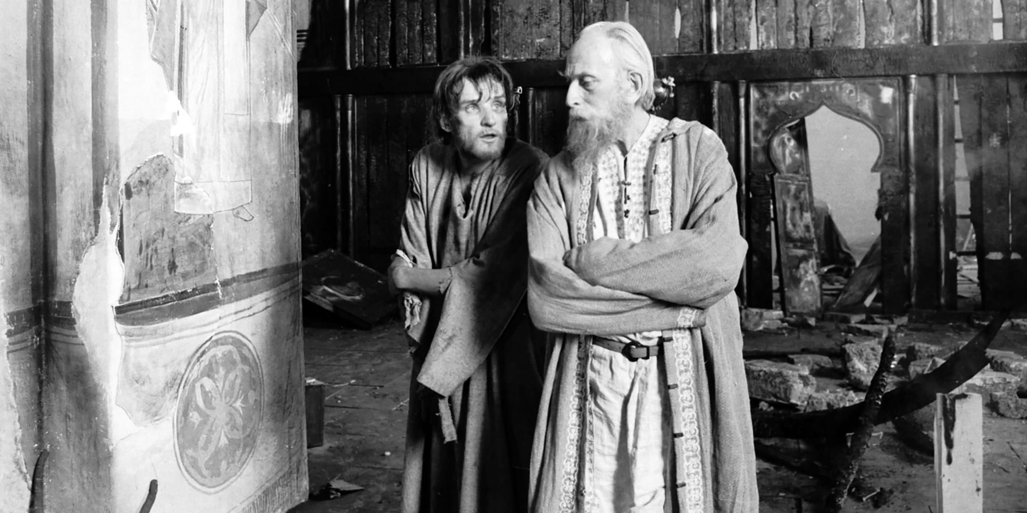 Andrei next to mysterious man in a ruined room in the film Andrei Rublev