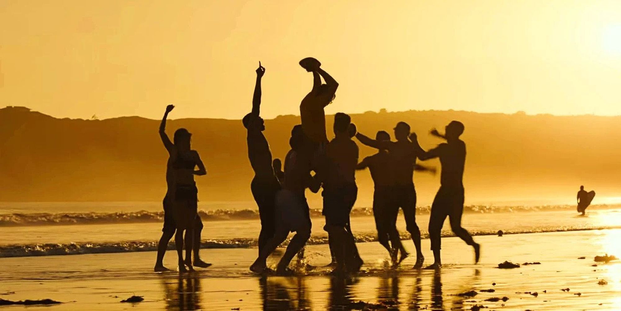 The team from Top Gun: Maverick in the beach, during the sunset, playing football