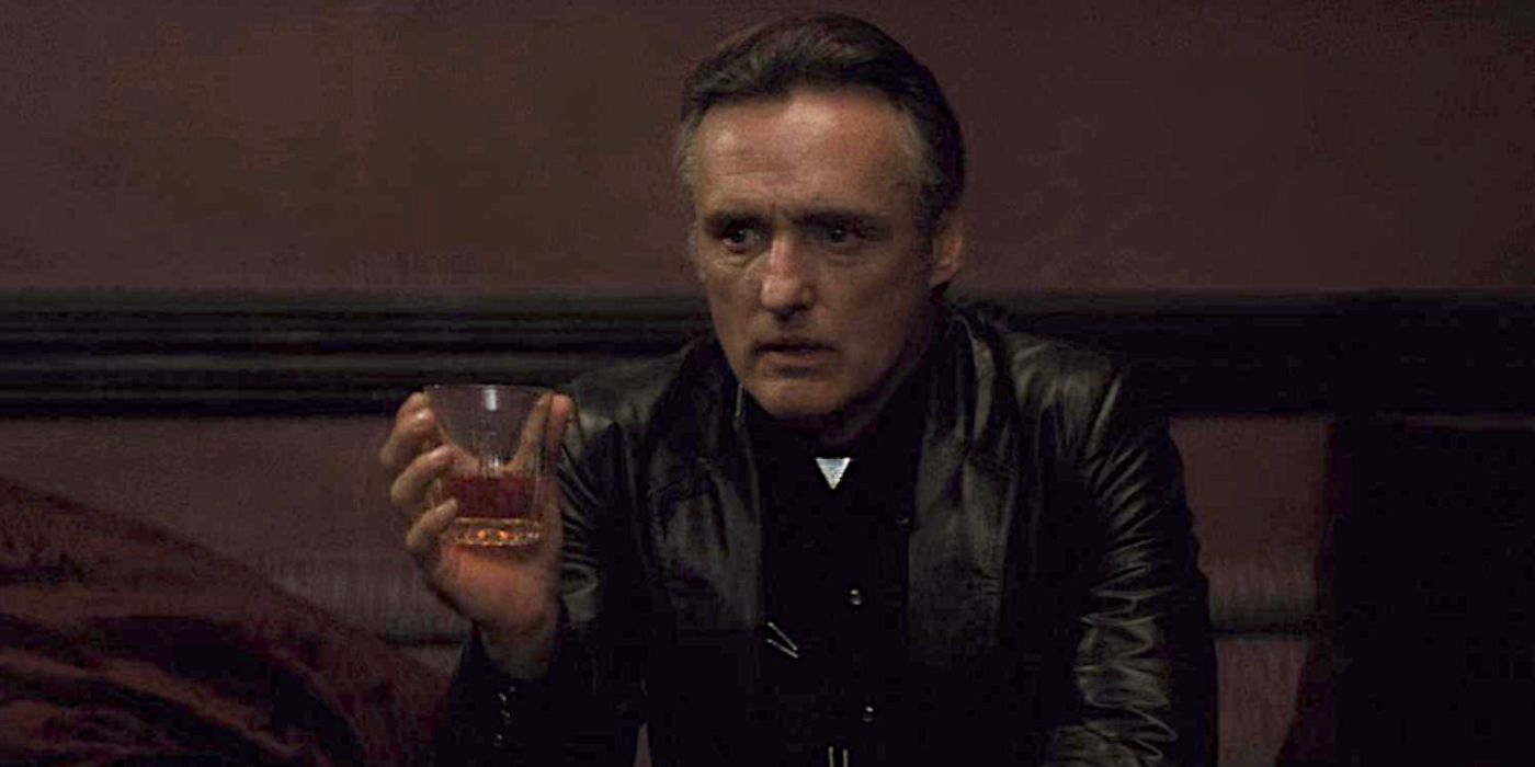 Frank Booth holding a glass and looking intently ahead in Blue Velvet