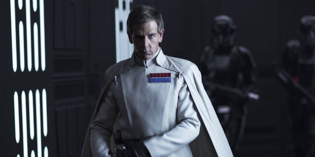 Director Krennic makes his way through a facility accompanied my Death Troopers