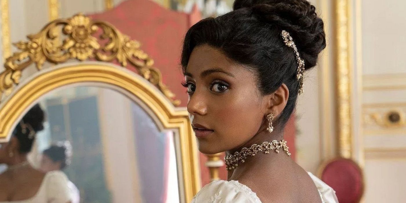 A close-up of Edwina Sharma with her hair in a bun and standing in front of a mirror.