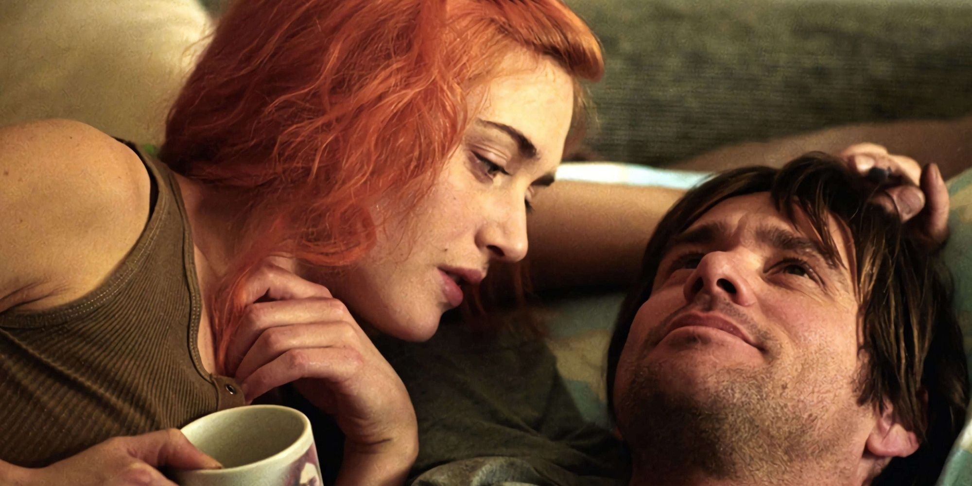 Kate Winslet and Jim Carrey laying with each other drinking coffee.